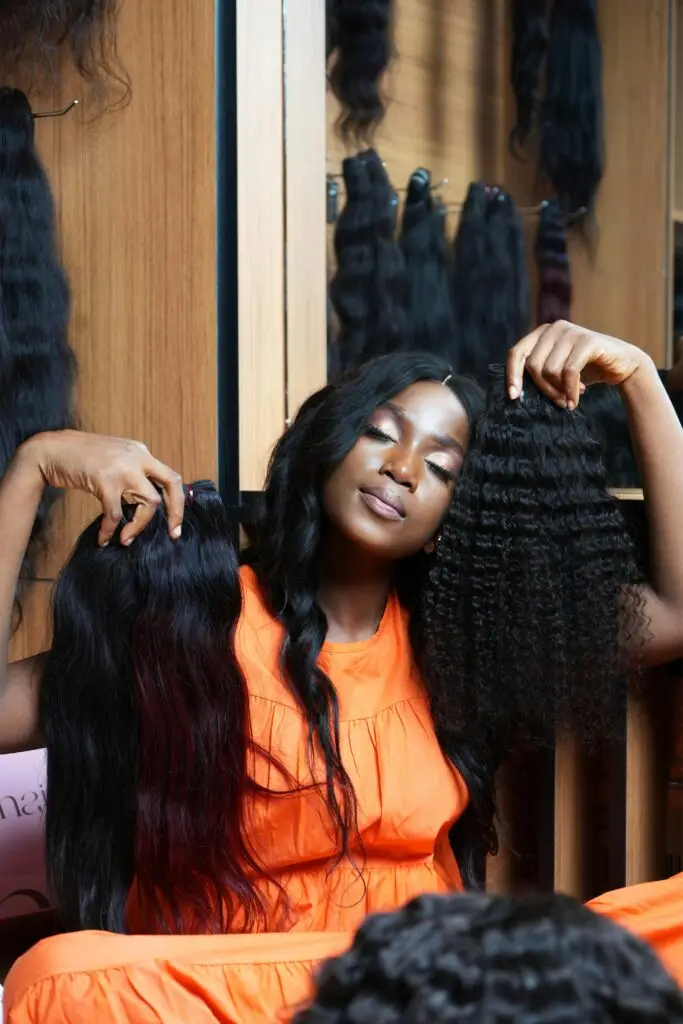 Lady Holding 2 Black Wigs | JLO Beauty Supply in Tampa FL